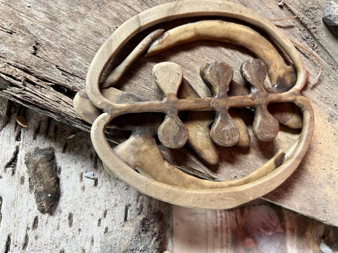 Detail of a cast brass motif on a wooden workbench